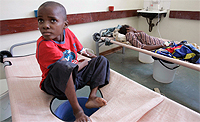 A boy rests on his bed in a cholera ward of Budiriro Polyclinic in Harare December 1, 2008. REUTERS/Philimon Bulawayo.