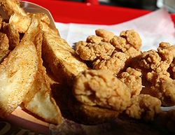 An order of french fries and chicken sit on a tray at a KFC fast food restaurant in New York October 30, 2006. KFC, a unit of Yum Brands Inc, on Monday said it will switch to a cooking oil with no trans fat in all its U.S. fried-chicken restaurants by April 2007. Yum Brands joins hamburger chain Wendy's International Inc as many local governments, including new York City, look at banning the artery-clogging trans fats. Fast-food restaurants have come under increasing criticism that their food contributes to obesity. REUTERS/Shannon Stapleton.