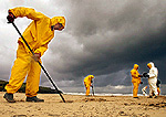 Soldiers clean up fuel oil on the Noja beach in the province of Santander in northern Spain February 4, 2003. "Crown Resources", the metals and energy trader, is suing the owners of the Bahamanian-flagged Prestige tanker which sank off the coast of Spain in November. The Swiss-based company had chartered the Prestige to carry 77,000 tonnes of fuel oil which is now spilling on to French and Spanish beaches. REUTERS/Victor Fraile.